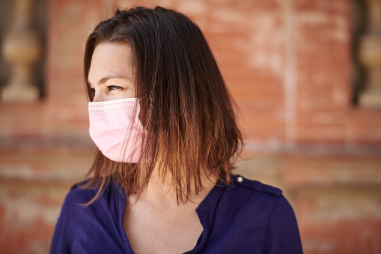 Femme portant un masque chirurgical rose auriol masque